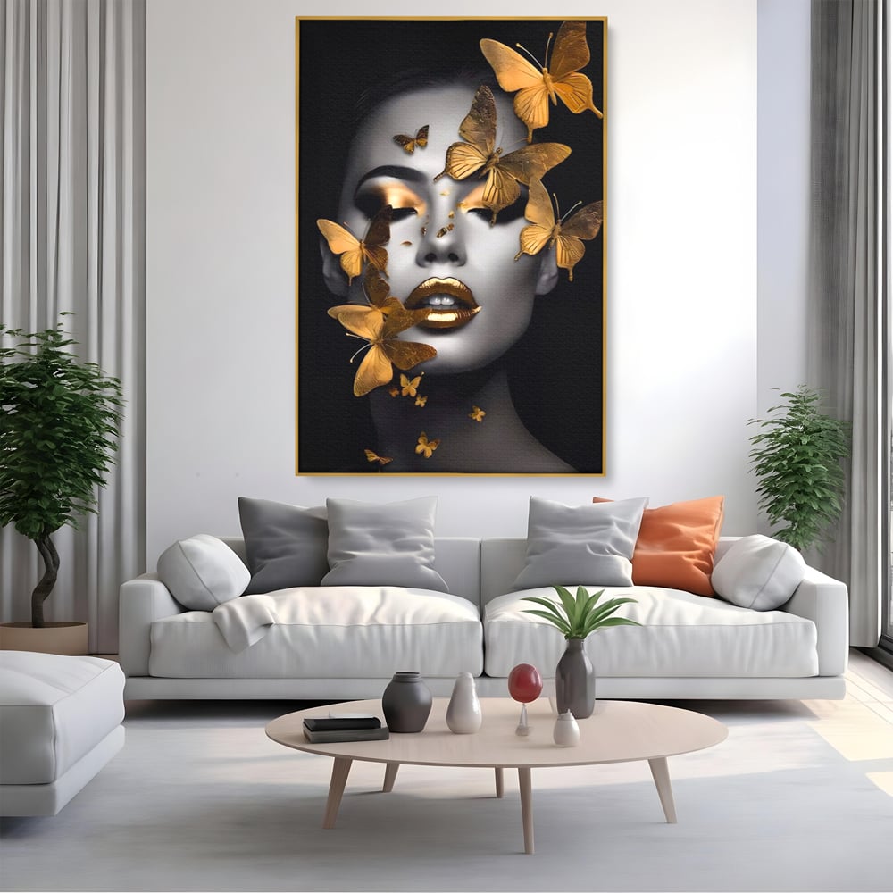 Tablou canvas cu tablou canvas cu portret de femeie si fluturi aurii, in rama de aluminiu auriu, pe perete intr-un living